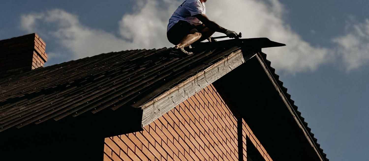 Dachdecker bei präzisen Dach- und Blecharbeiten auf einem Hausdach